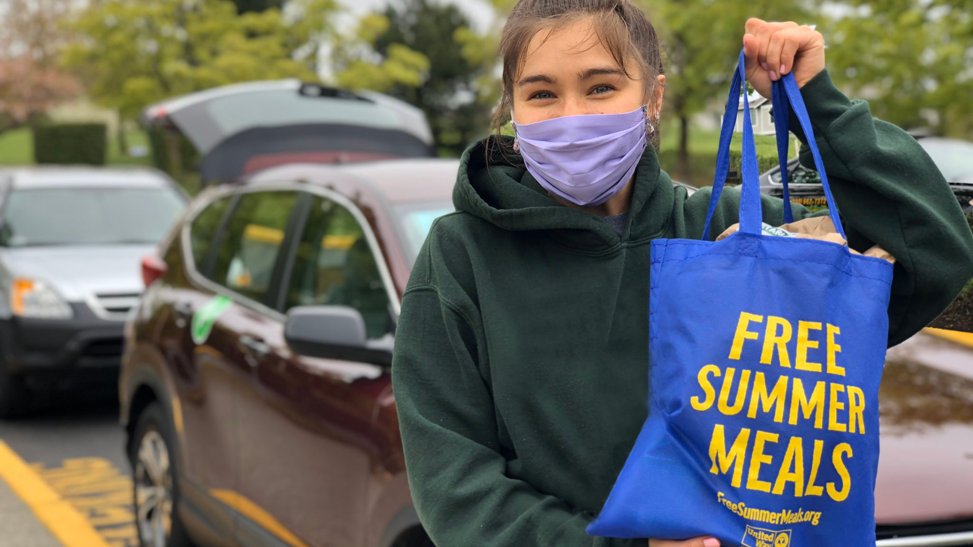 Woman smiling holding a bag of free food